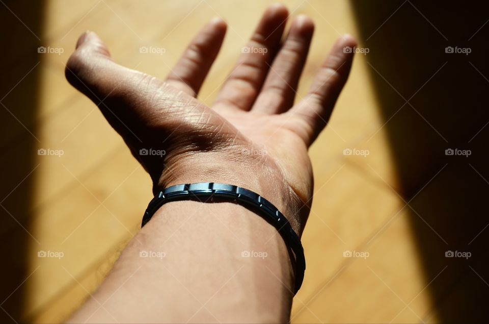 A man exercises his wrist using a magnetic bracelet containing tourmaline stones to increase strength.