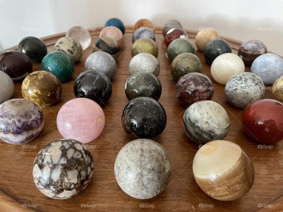 Multicolored polished crystal spheres - pink quartz, calcite, onyx, opal, brecciated jasper - various semiprecious stone balls for meditation.