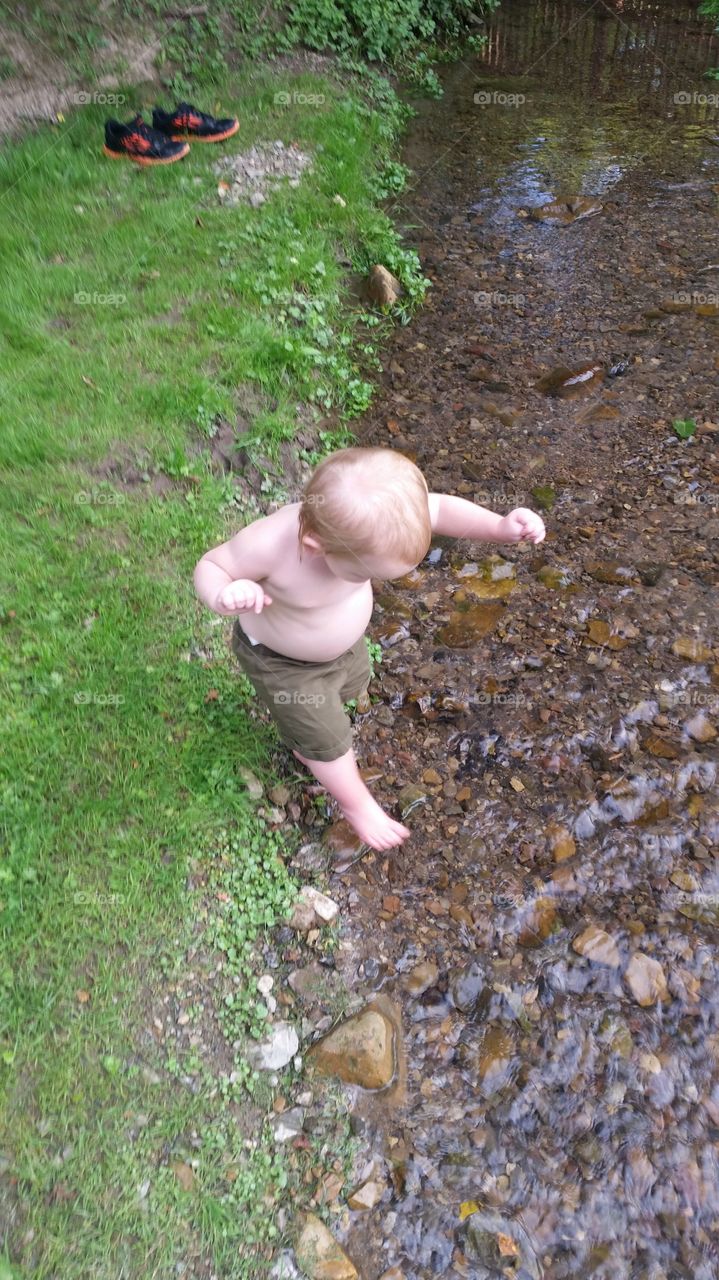creek playtime. little boy playing in stream