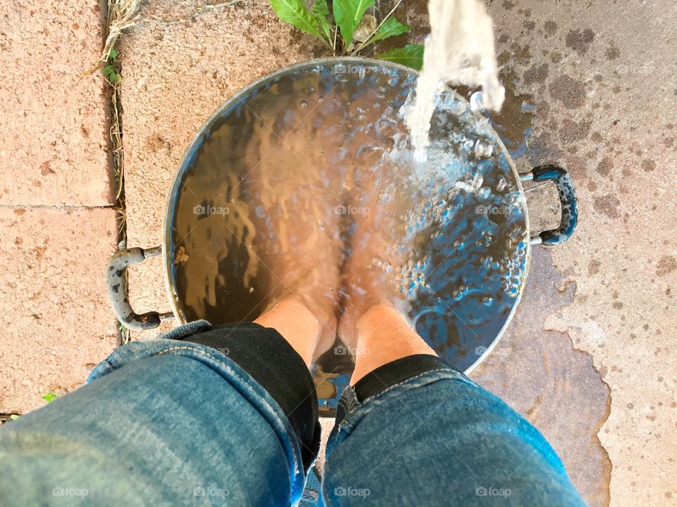 Where I stand in old tin bucket pot pail of water with faucet running to cool off