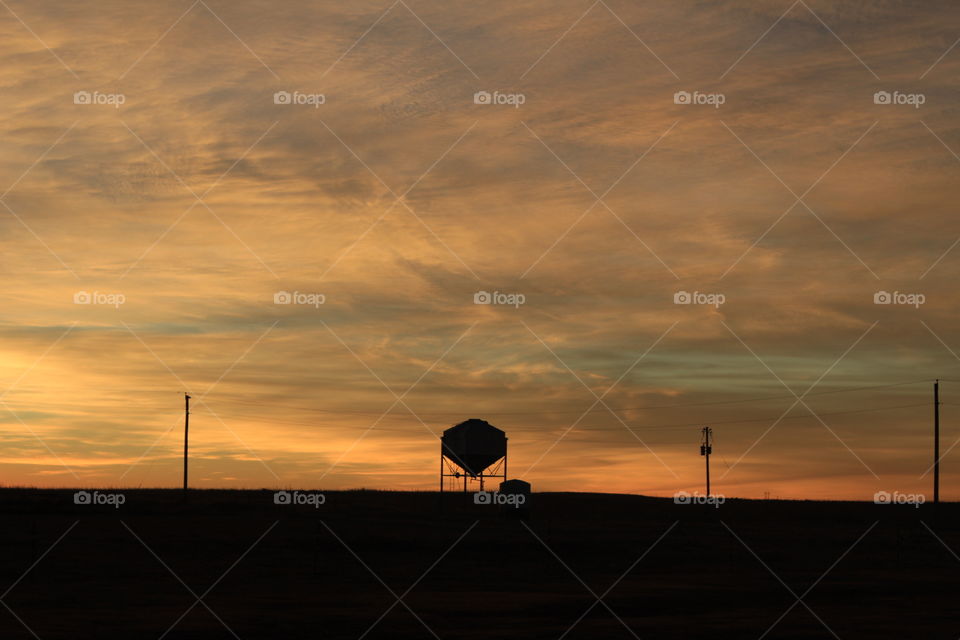 Beautiful sunrise in Southwest Kansas. Bold colors contrasting against the dark silhouette of a grain bin. 