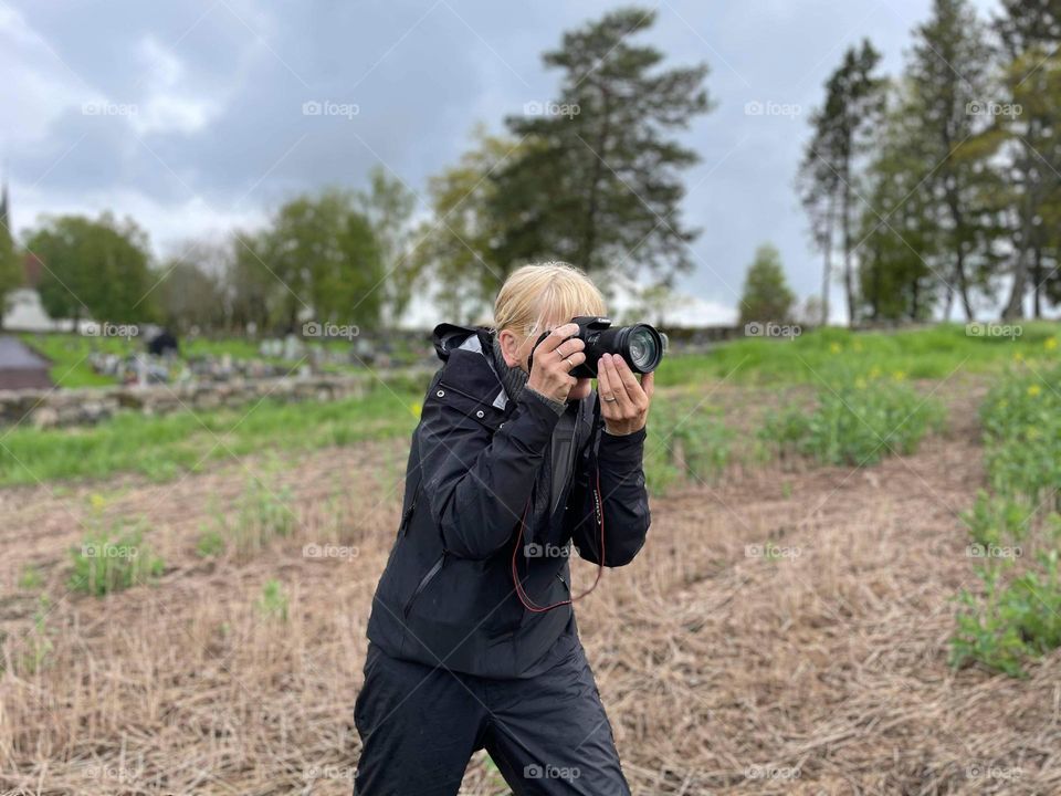 Grown up woman doing photography outdoor into the nature