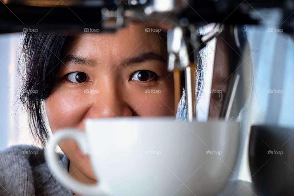 A young lady of Taiwanese decent is super excited about her espresso. 