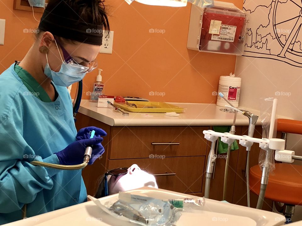 Dentist, dental, hygienist, hygiene, dental hygienist,dental hygiene, tools, teeth, tooth, cleaning, tray, mask, woman, female, gloves, blue, orange, counter, light, brunette, dentist office, office, exam, examination, dental exam, patient, medicine 