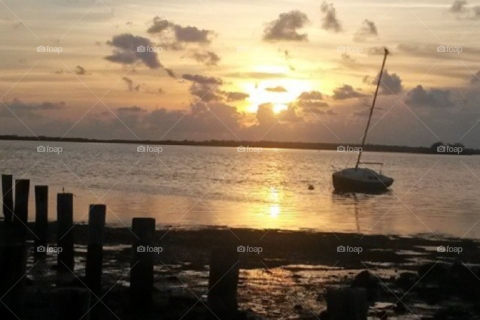 Beautiful sunset overlooking the bay with a stranded boat.