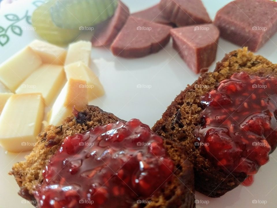a small lunch, homemade banana bread with jam, meat, cheese, pickles
