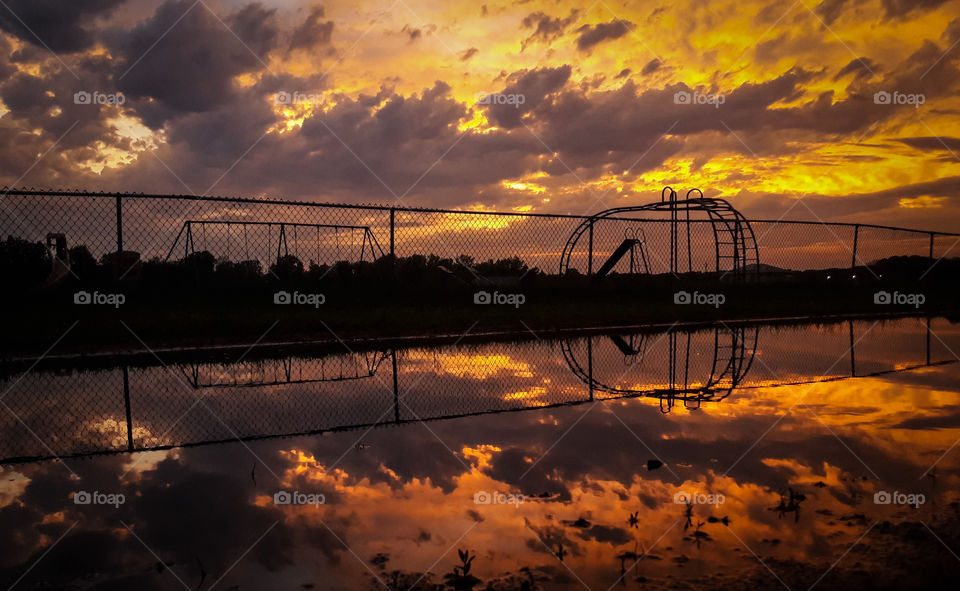 Mirror reflection of a sunset in a puddle, after a storm.