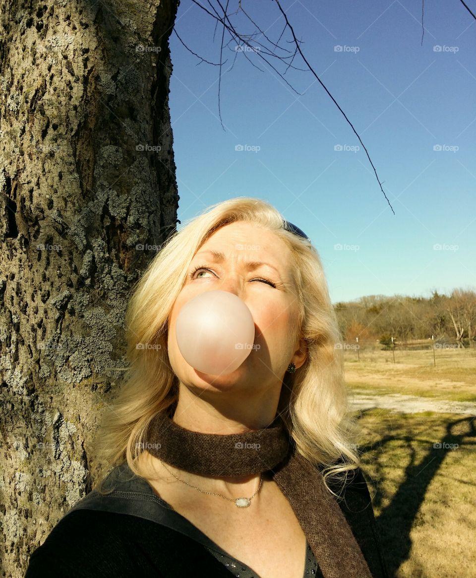 Portrait of a mature woman blowing chewing gum