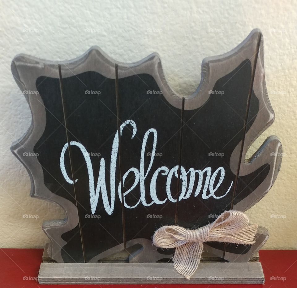 A Black And Grey Painted Welcome Sign Crafted From Repurposed Wood And Finished With A Pink Bow