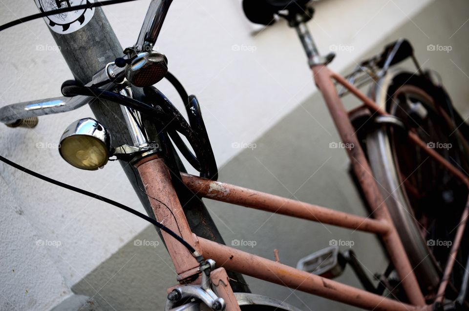 Ein altes rosa Fahrrad, ist ein eine Laterne gebunden. 