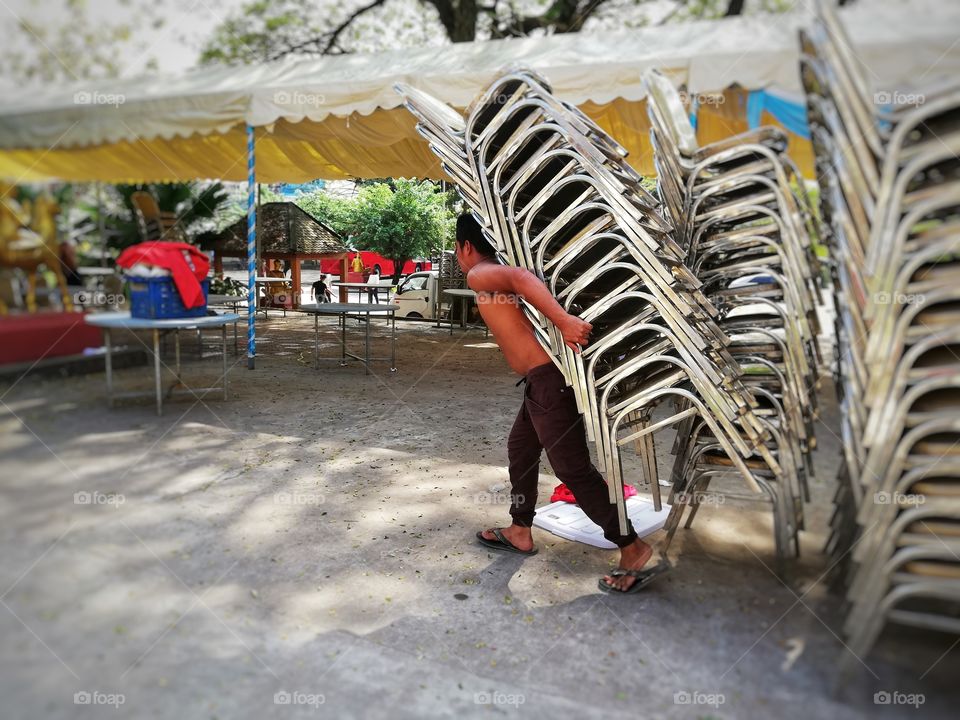 Cambodian workers carry a stack of chairs