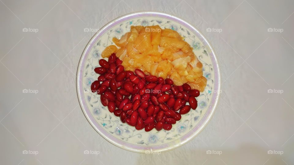 A plate of red beans and raw chicken captured from above