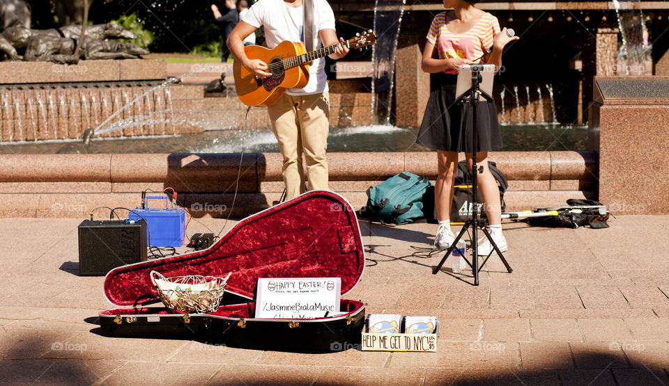 photo story, teenagers singing at the park for a cause to save for college fund according to the sign