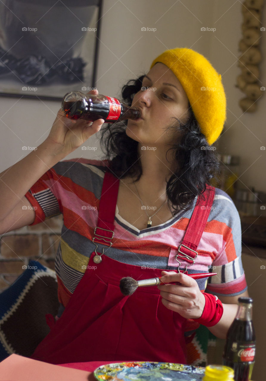 A woman artist drinking Coca-Cola from the bottle