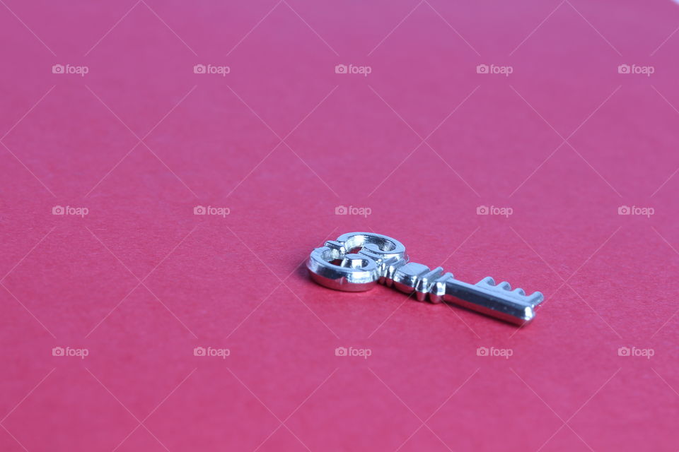 miniature toy key on red background