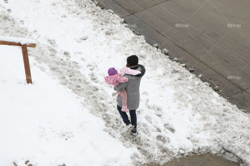 Woman carries baby in winter snow