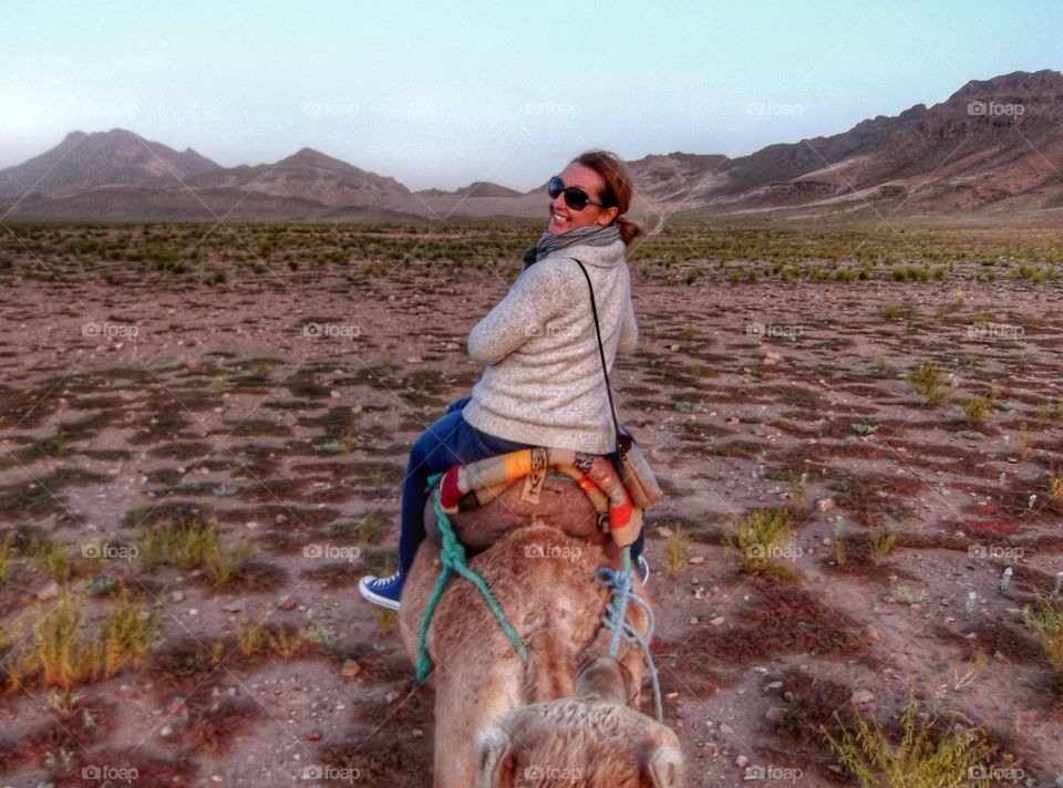 Woman sitting on camel in desert