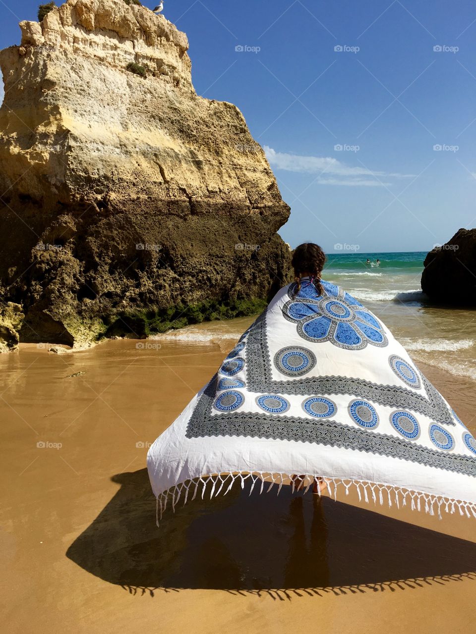 Girl carrying blanket on beach