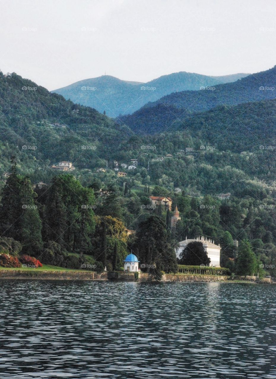 Lake Como. A tiny blue gazebo beneath the Italian Alps reflected in Lake Como