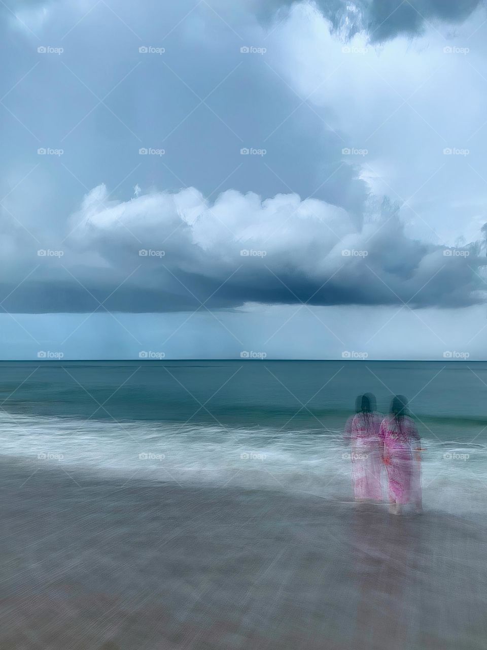 Atlantic Ocean Beach With Time In Motion Long Exposure Of The Waves And A Child Watching The Storm On The Seashore During A Thunderstorm With Dark Grey Clouds.