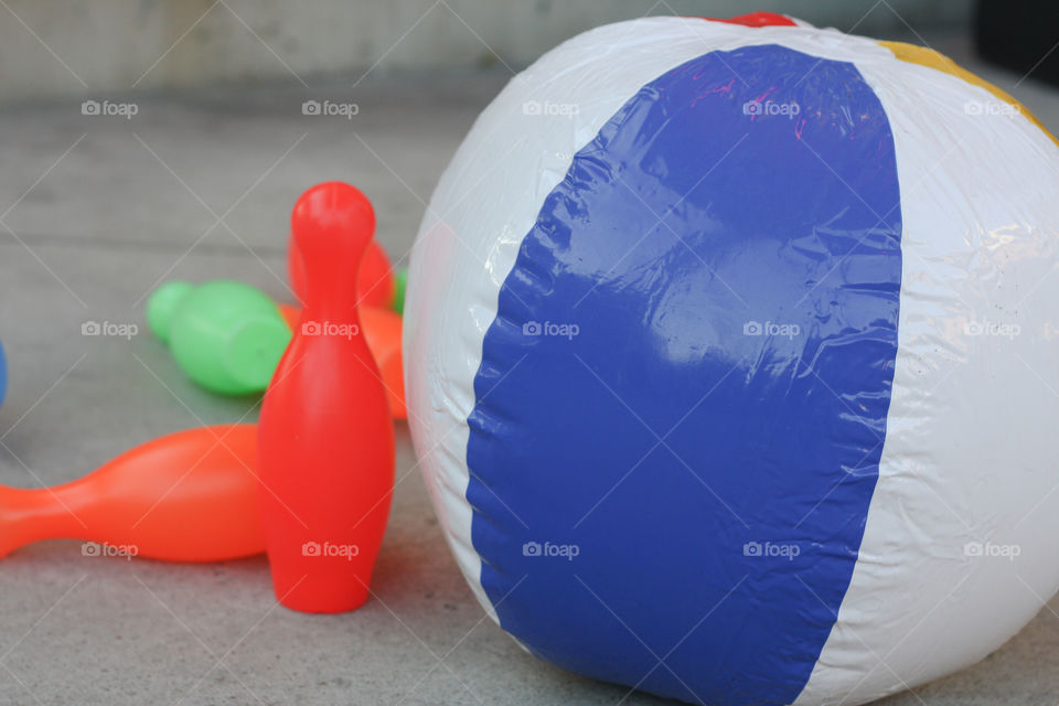 A game of bowling with an inflatable beach ball and plastic bowling pins 