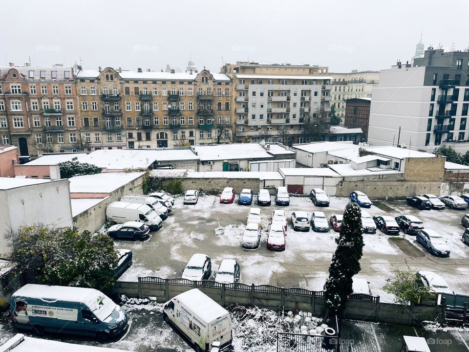 Snow-Covered Urban Parking Lot Amidst Architectural Diversity