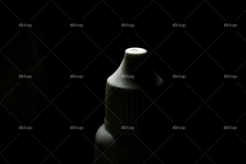 A flask, a medical bottle, eye drops. High Contrast, black and white.