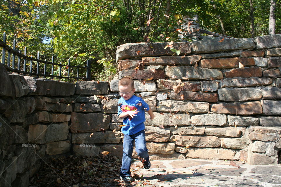 Boy playing in autumn leafs