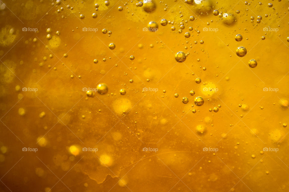 Bubbles in honey coloured liquid soap, background