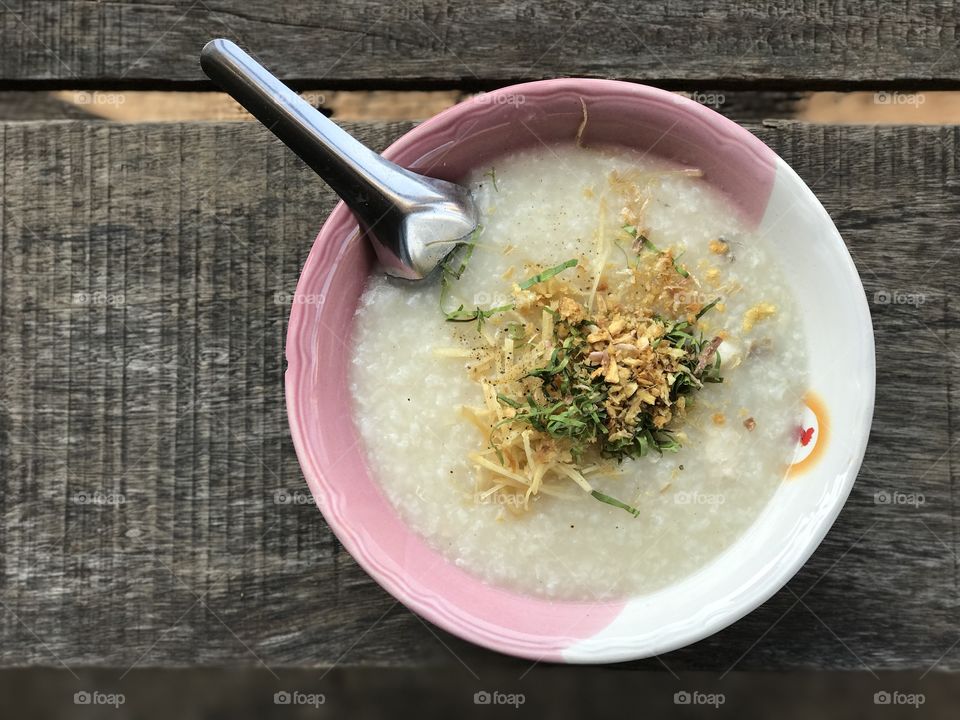 Rice porridge with pork sprinkled with sliced ginger and deep-fried garlic
