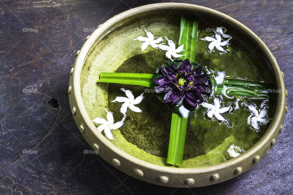 Spa therapy with flowers on water in bowl