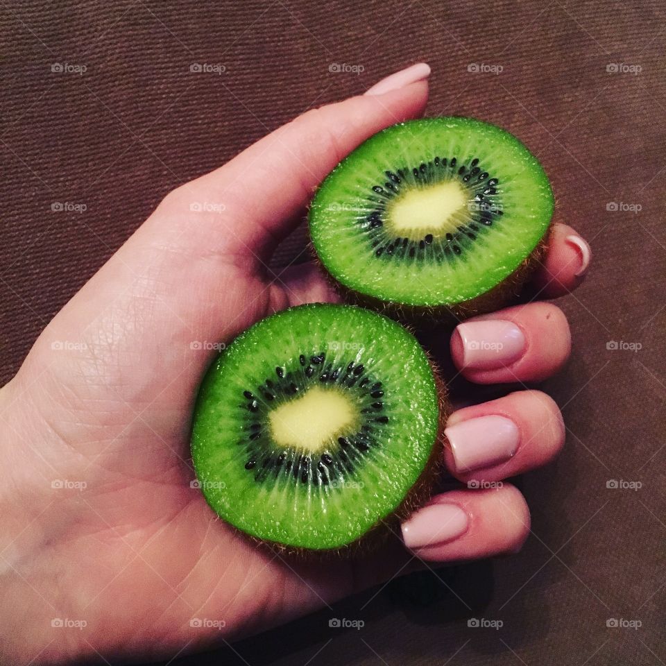 Hand's holding kiwi fruit