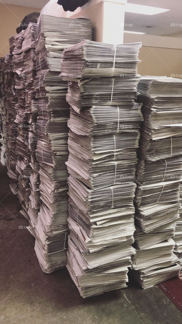 Stacks of newspapers waiting to be delivered in the early morning 