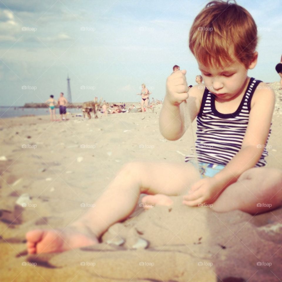 Beach . boy on the beach playing with sand