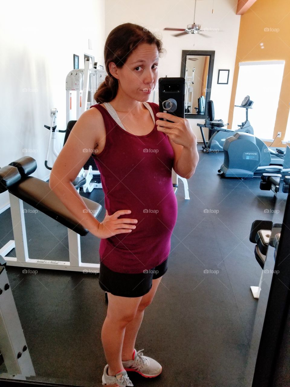 Pregnant self at gym in front of mirror