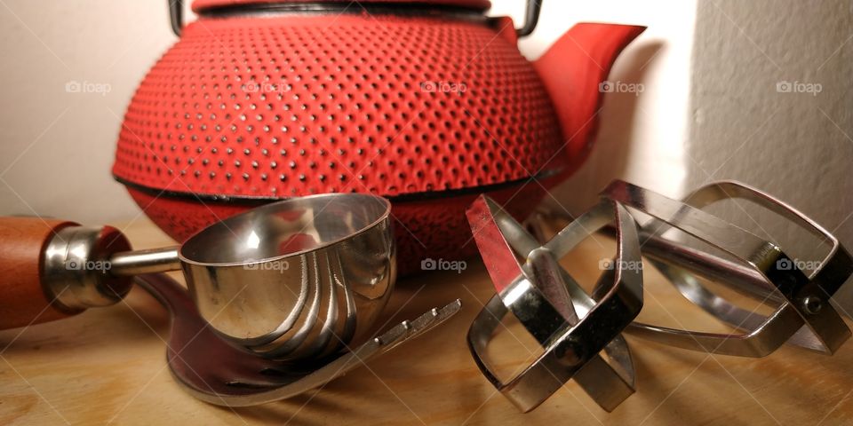 Some kitchen utensil photographed with macro technique, working on exposure, light, focus and depth of field. The red teapot is the background in this picture.