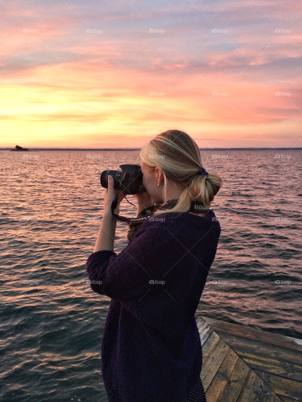 Women holding camera during sunset