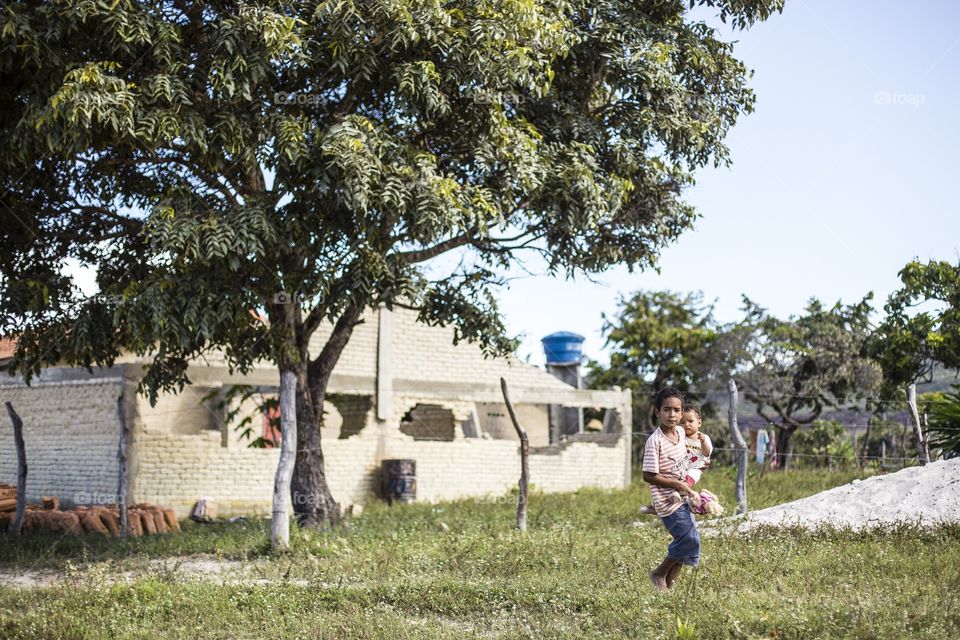 Brotherhood. A boy carries his young brother in Cavalcante, a small village near Brasilia, Brazil