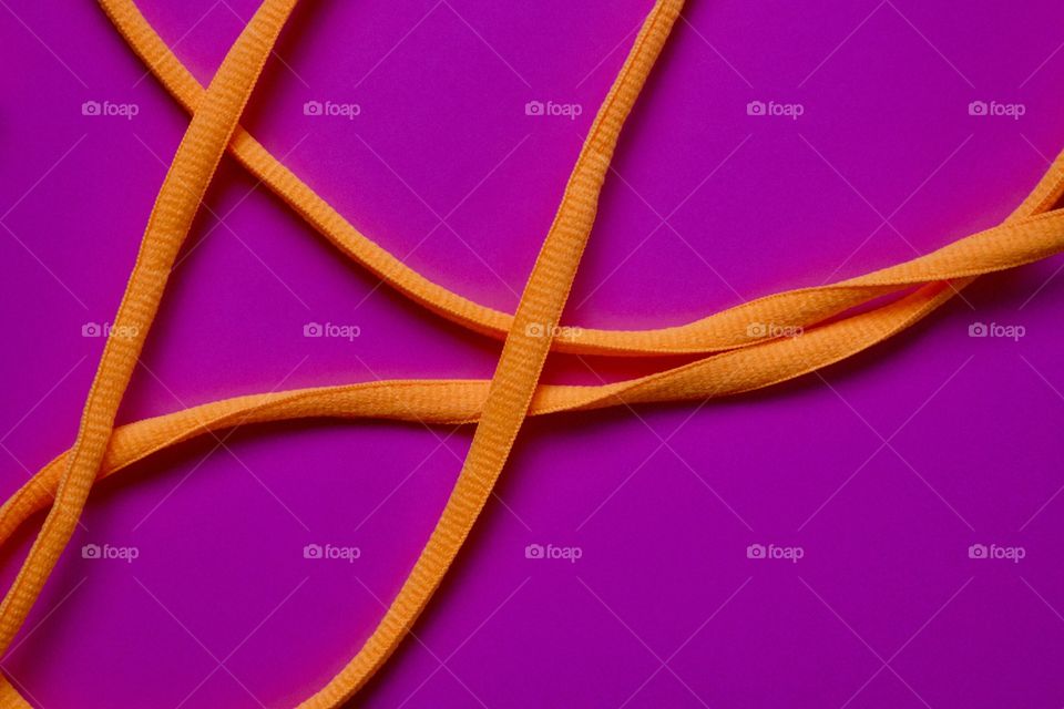 Neon orange nylon cord on a bright fuchsia background 