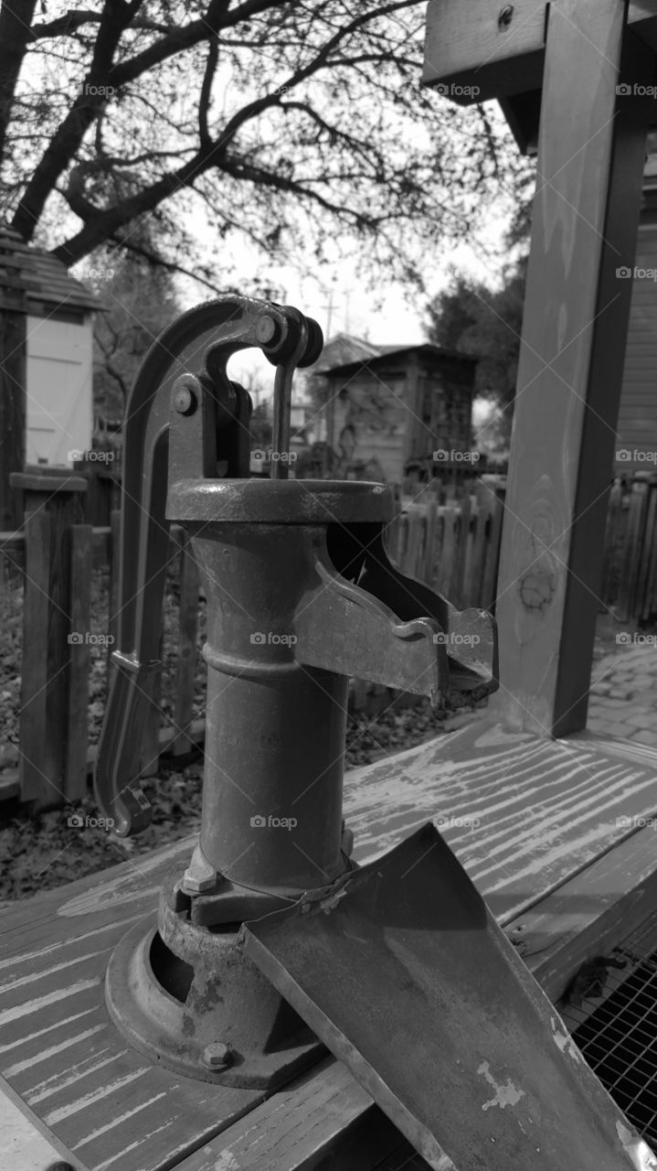 a small well pump set up for kids to try in a history park. This section was a small recreated farmhouse with garden , chicken coop and of course the well and pump