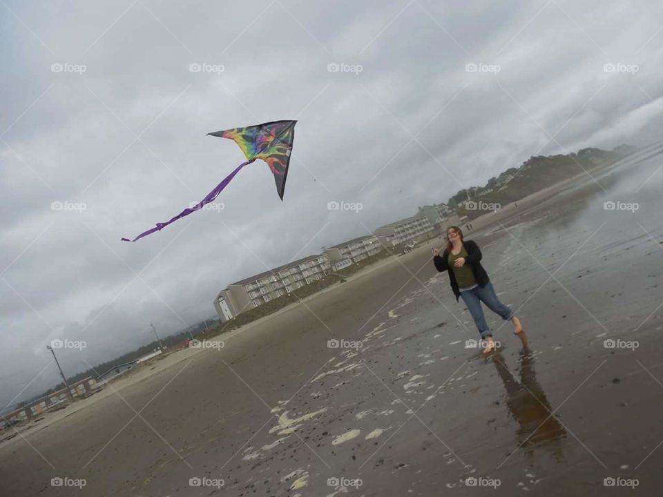woman flying a kite on the beach