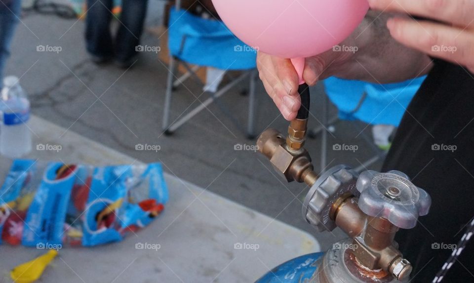 Helium tank filling pink balloon