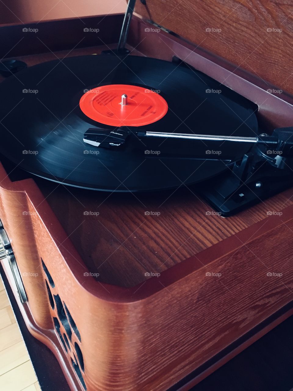 Vinyl record playing music on a vintage antique style wooden record player. 