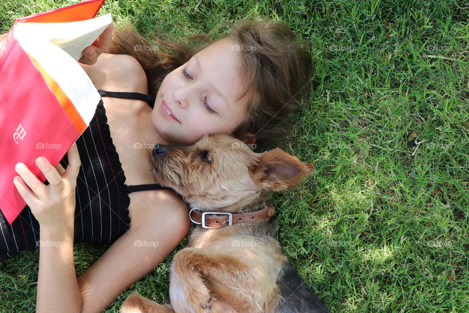 Child reading a story to their dog