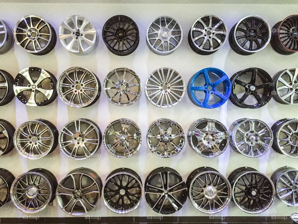 A variety of rims hanging on a wall in a local car dealership.