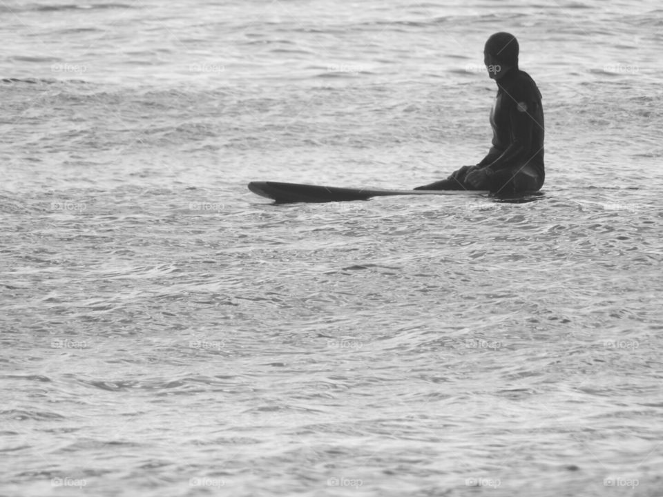 Just the surfer and his board waiting for the perfect ride.