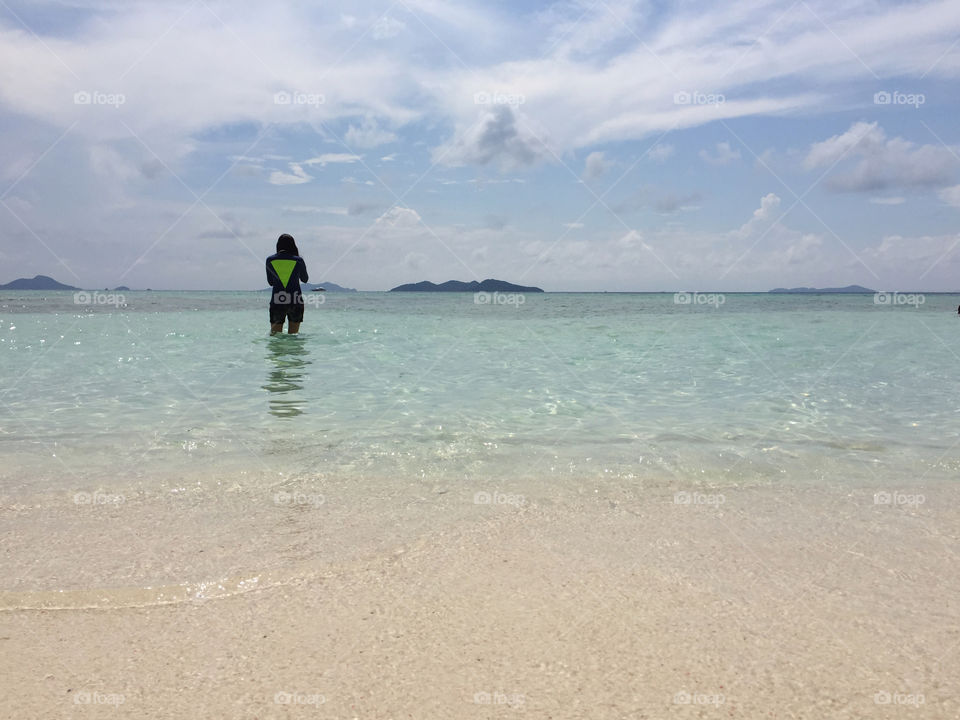 One woman standing in front of a beach