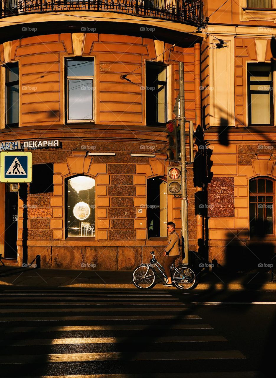 Young woman with bicycle on the street in a sunny summer day