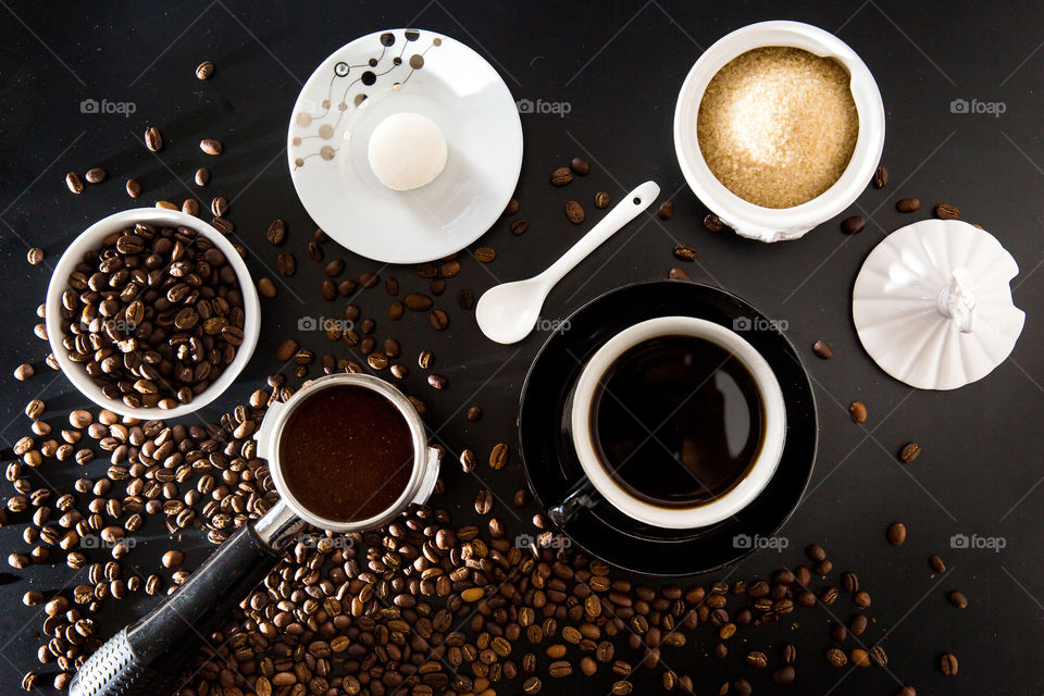 Flat lay of coffee from bean to cup with coffee beans porta filter coffee sugar and cookie. Beautiful flat lay for shapes with round and ellipse shapes