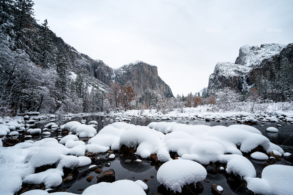 View of river with mountains in background during winter.